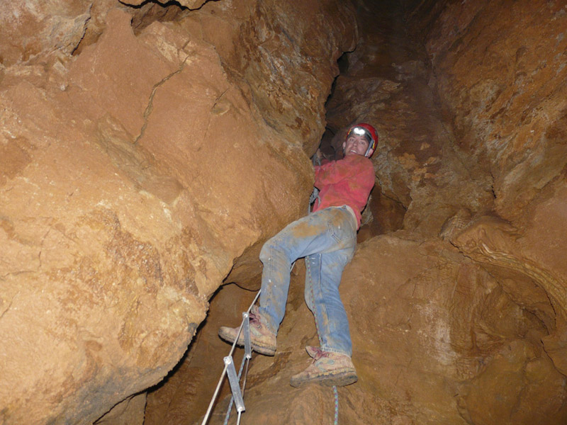 Un spéléologue descend dans une cavité souterraine.