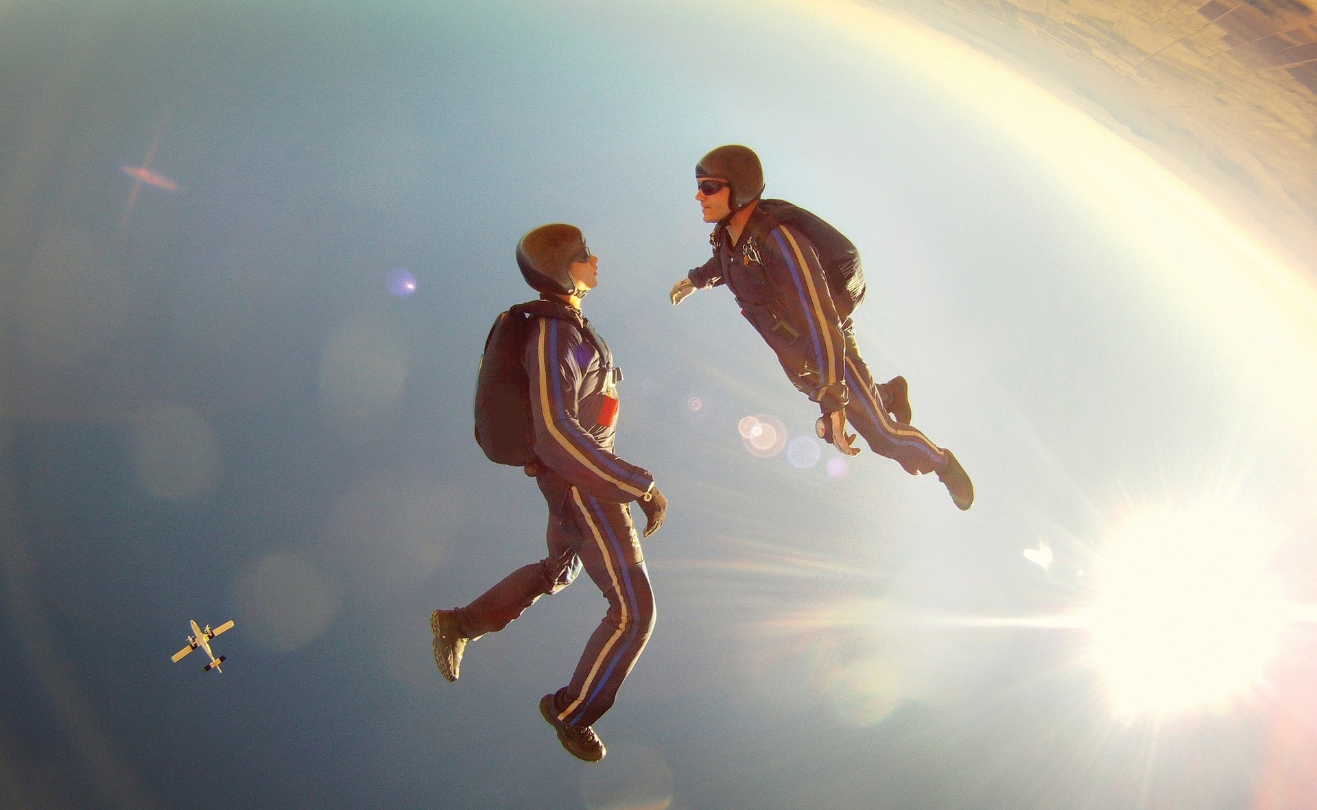 Un instructeur de sauts en parachute avec un élève en pleine chute libre.